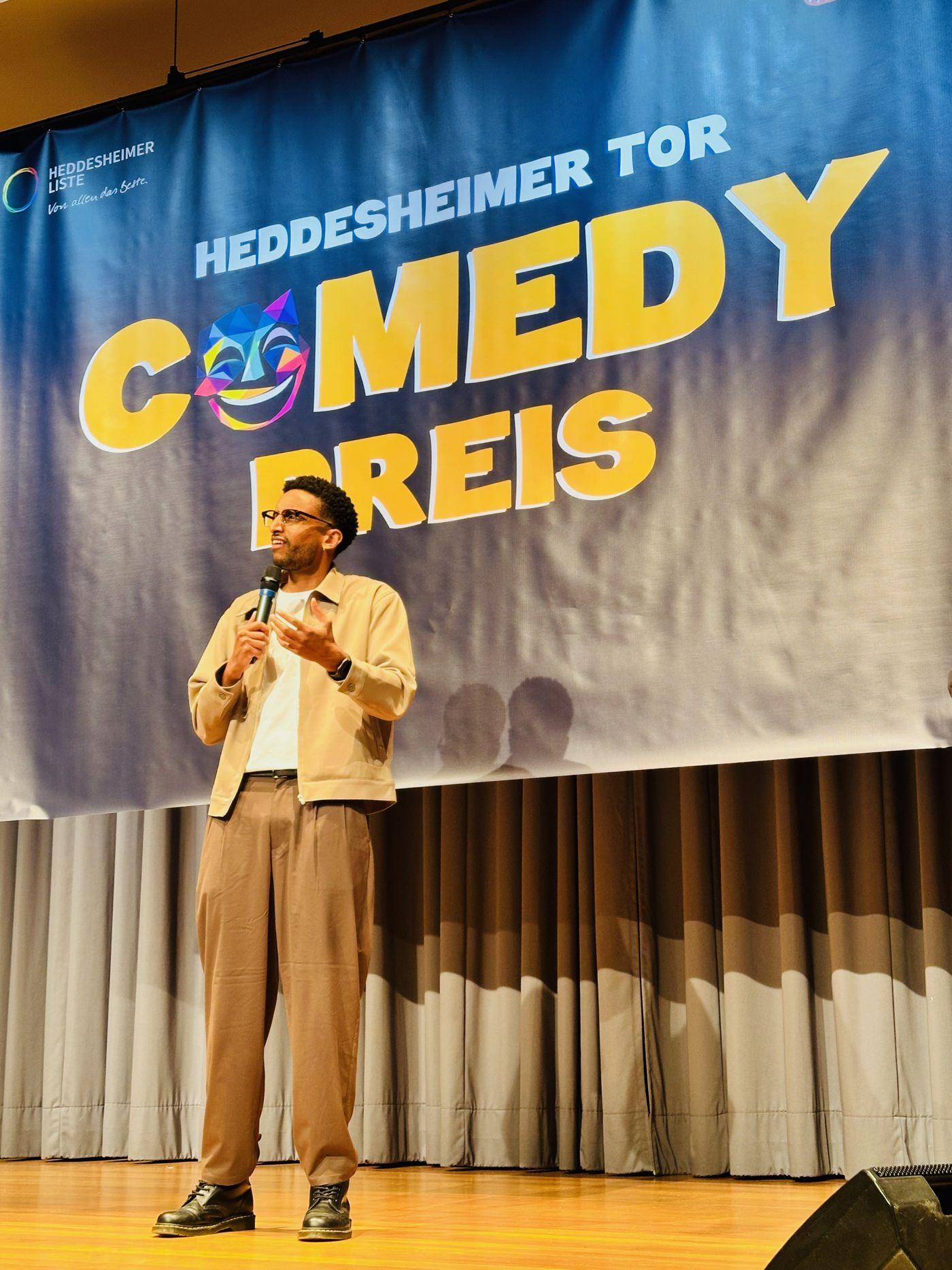 Comedian in heller Jacke spricht ins Mikrofon